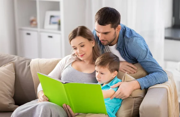 Happy family reading book at home — Stock Photo, Image