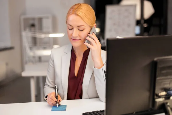 Mujer de negocios llamando a sartphone en la oficina nocturna —  Fotos de Stock