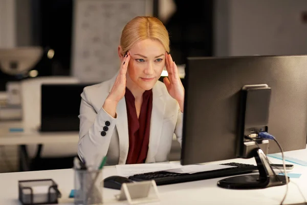 Affärskvinna med dator på natt kontor — Stockfoto