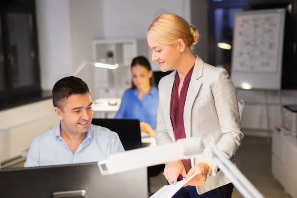 Team aziendale con documenti che lavorano fino a tardi in ufficio — Foto Stock