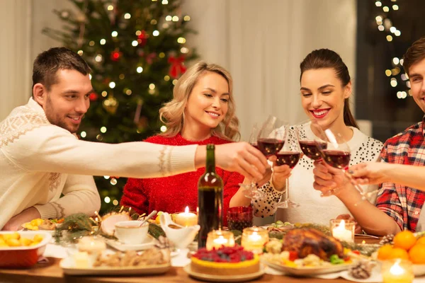 Amigos felizes bebendo vinho tinto na festa de Natal — Fotografia de Stock