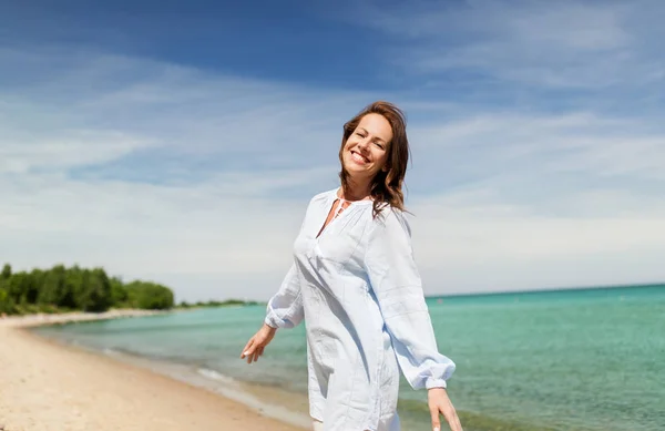 Szczęśliwy uśmiechający się kobieta na plaży latem — Zdjęcie stockowe