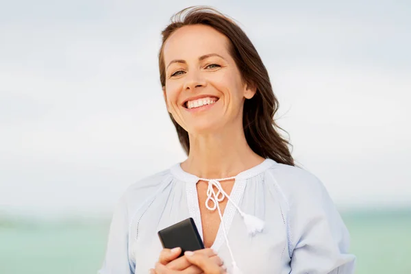 Šťastná žena s smartphone na letní beach — Stock fotografie