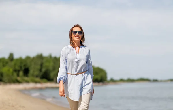 Happy smiling woman walking along summer beach — Stock Photo, Image