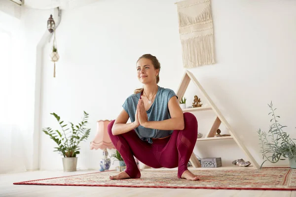 Joven mujer haciendo guirnalda pose en yoga studio — Foto de Stock