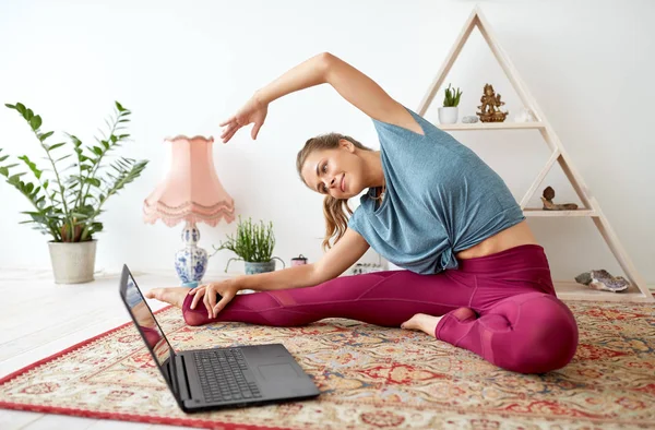 Kvinna med laptop träning på yoga studio — Stockfoto