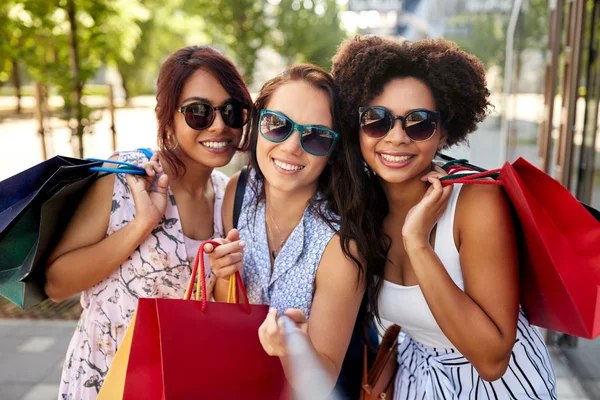 Mulheres felizes com sacos de compras na cidade — Fotografia de Stock
