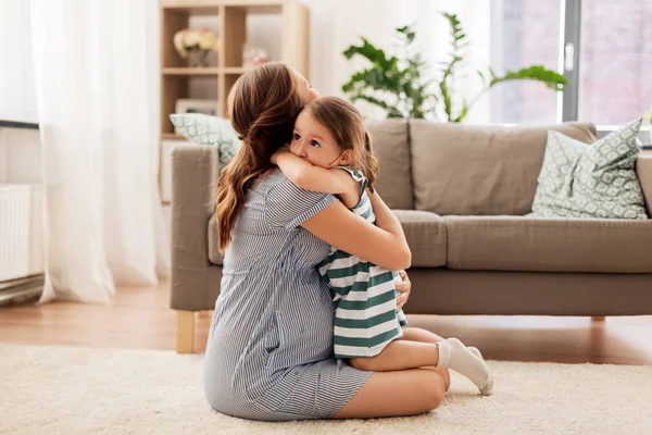 Mère enceinte et fille étreignant à la maison — Photo