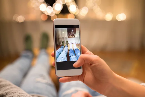 Крупним планом пара фотографує ногами за допомогою смартфона — стокове фото
