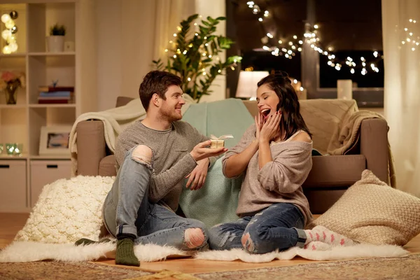 Coppia felice con scatola regalo a casa — Foto Stock