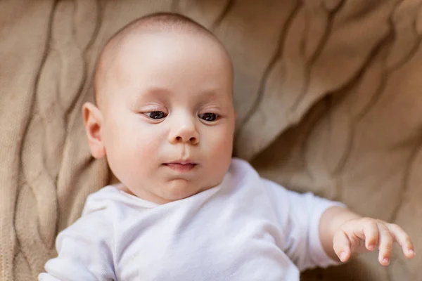 Süßer kleiner Junge liegt auf Strickdecke — Stockfoto