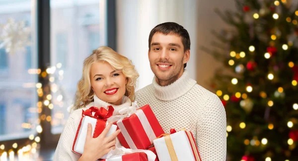 Ευτυχισμένο ζευγάρι με χριστουγεννιάτικα δώρα στο σπίτι — Φωτογραφία Αρχείου