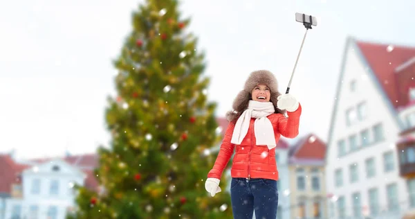 Woman taking selfie over christmas tree — Stock Photo, Image