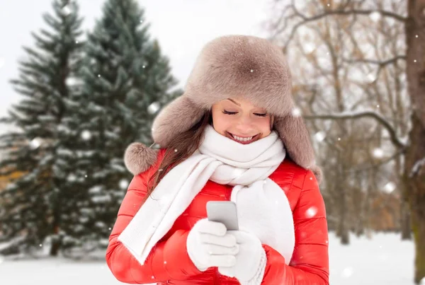 Lycklig kvinna med smartphone i vinter — Stockfoto