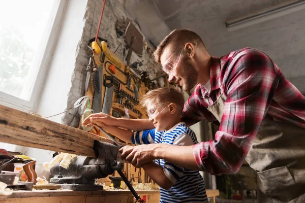 Father and son with rasp working at workshop — Stock Photo, Image