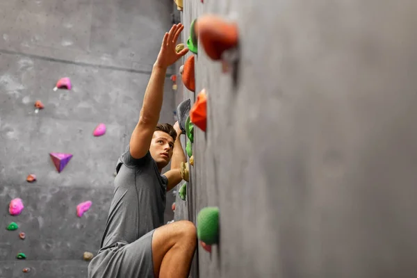 Junger Mann trainiert in Kletterhalle — Stockfoto