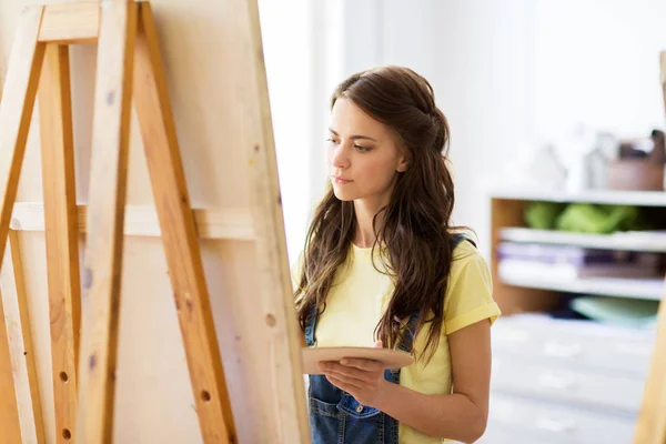Студентка з мольбертовим живописом у художній школі — стокове фото