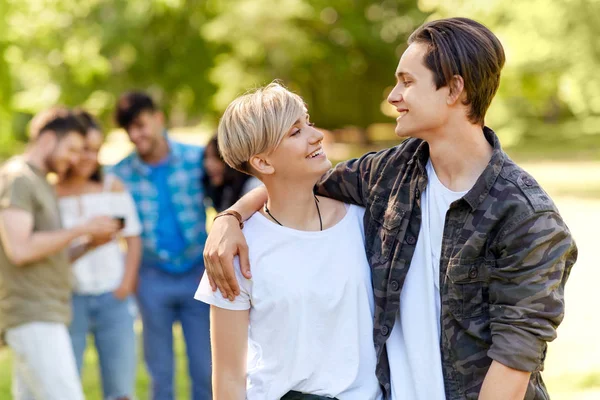 Happy teenage couple hugging at summer park — Stock Photo, Image