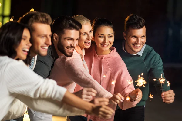 Amigos felices con bengalas en la fiesta en la azotea — Foto de Stock