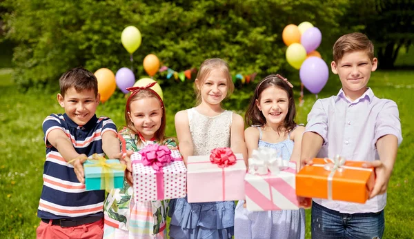 Gelukkige jonge geitjes met giften op verjaardagsfeestje op de zomer — Stockfoto