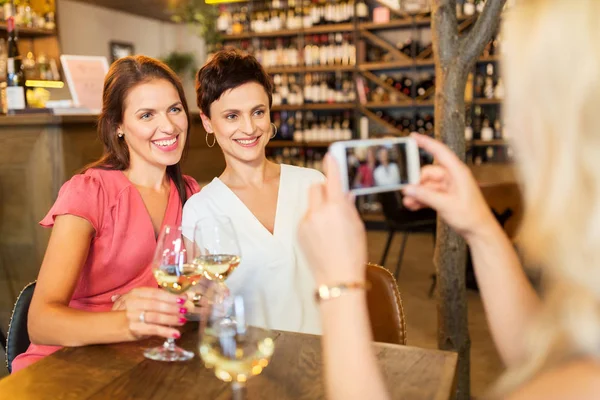 Kvinna föreställande vänner av smartphone i vinbaren — Stockfoto
