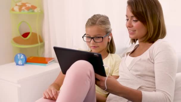Mother and daughter listen to music on tablet pc — Stock Video