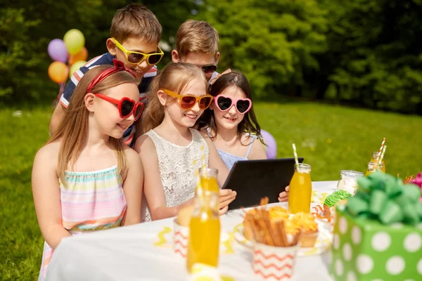 Niños felices con la PC tableta en la fiesta de cumpleaños —  Fotos de Stock