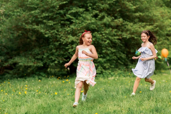 Meninas felizes jogando jogo de tag na festa de aniversário — Fotografia de Stock