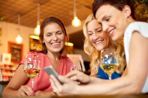 Mujeres con smartphone en bar de vinos o restaurante — Foto de Stock