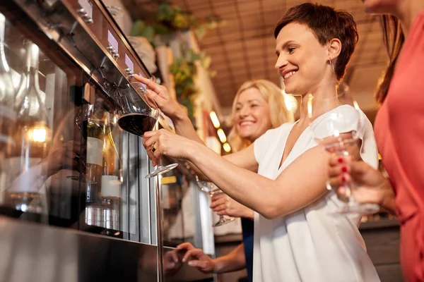 Mutlu kadın şarap dispenseri üzerinden dökülen bar — Stok fotoğraf