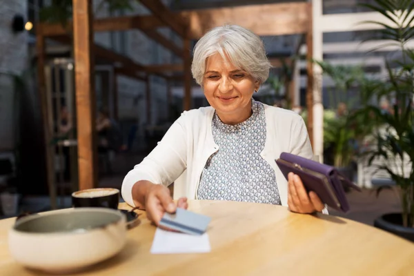 Seniorin mit Kreditkartenrechnung im Café — Stockfoto