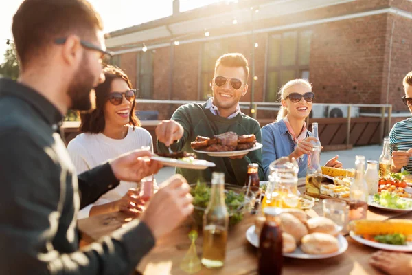 Amigos felizes comendo na festa de churrasco no telhado — Fotografia de Stock