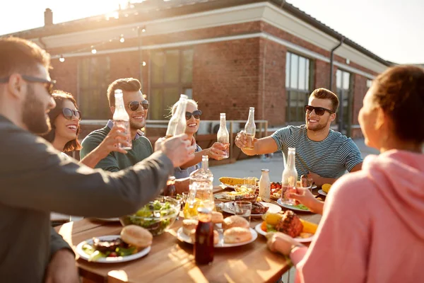 Amigos felices brindar bebidas en la fiesta en la azotea — Foto de Stock