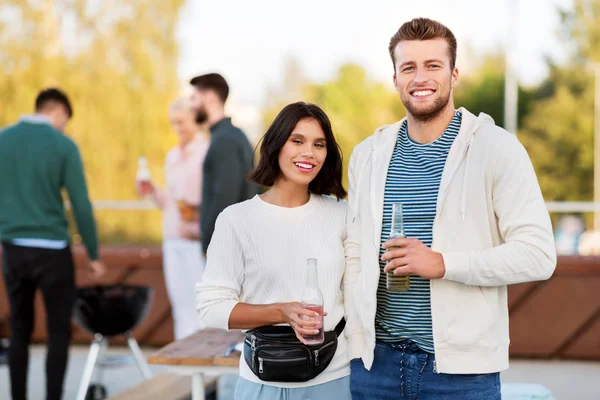 Счастливая пара с напитками на вечеринке на крыше — стоковое фото
