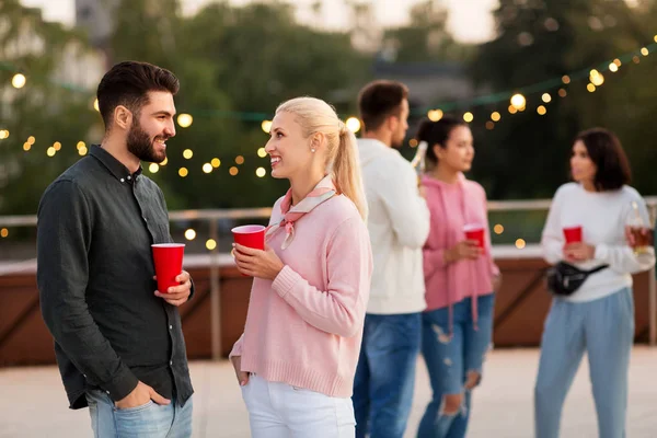 Amis avec des boissons dans des tasses de fête sur le toit — Photo