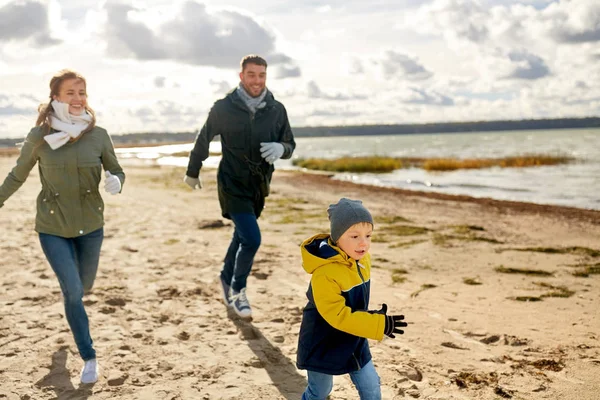 Mutlu aile sonbahar plaj boyunca çalışan — Stok fotoğraf