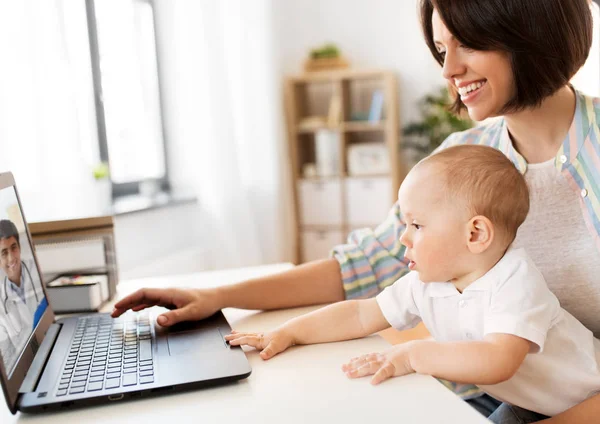 Mère avec bébé avoir un chat vidéo avec le médecin — Photo