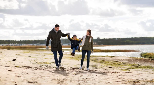 Família feliz andando ao longo da praia de outono Fotografias De Stock Royalty-Free