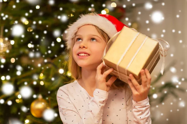 Chica sonriente en sombrero de santa con regalo de Navidad — Foto de Stock