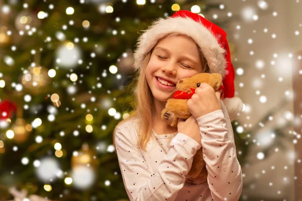 Leende flicka i tomte hatt med julklapp — Stockfoto