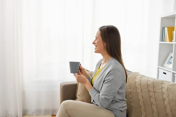 家でお茶やコーヒーを飲む幸せな女 — ストック写真