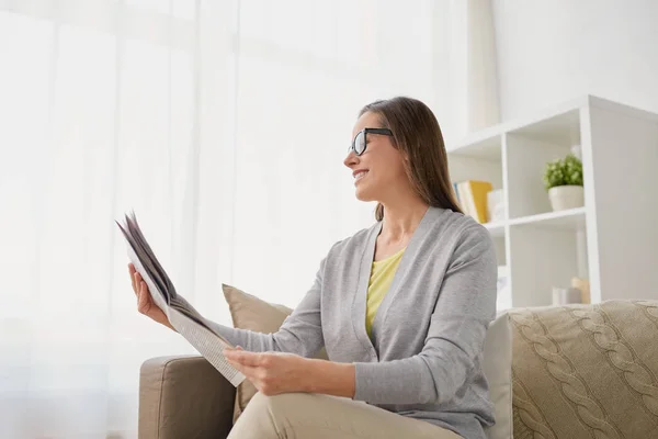 Mujer feliz leyendo el periódico en casa —  Fotos de Stock