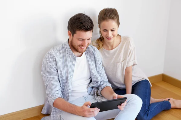 Gelukkig paar met tablet pc computer in nieuw huis — Stockfoto