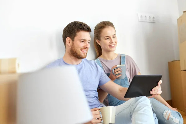 Pareja con la computadora de la PC de la tableta que se mueve a nuevo hogar —  Fotos de Stock