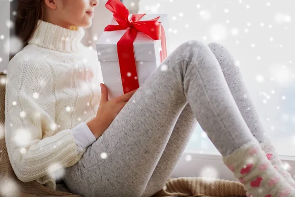 Chica con regalo de Navidad sentado en el alféizar en casa — Foto de Stock