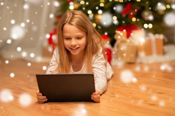 Chica sonriente con la tableta de la PC en casa de Navidad —  Fotos de Stock