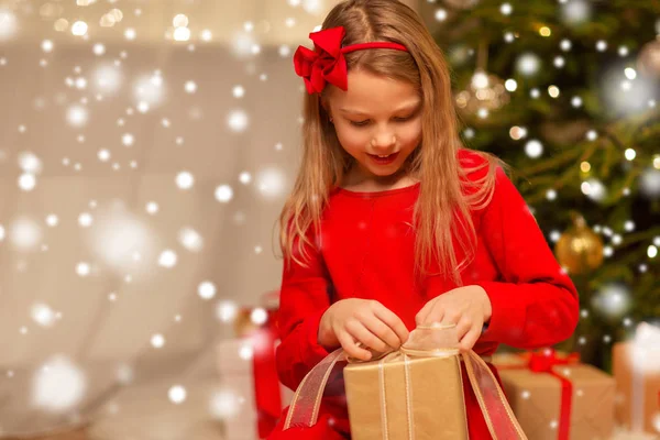 Leende flicka med julklapp hemma — Stockfoto