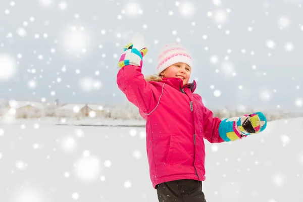 Chica feliz jugando y lanzando bola de nieve en invierno —  Fotos de Stock