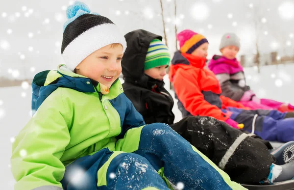 Glückliche kleine Kinder beim Schlittenfahren im Winter — Stockfoto