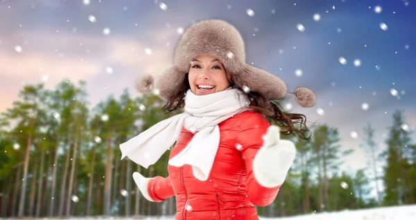 Gelukkig vrouw in bont hoed over winter bos — Stockfoto